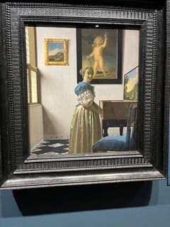 ヴァージナルの前に立つ若い女性